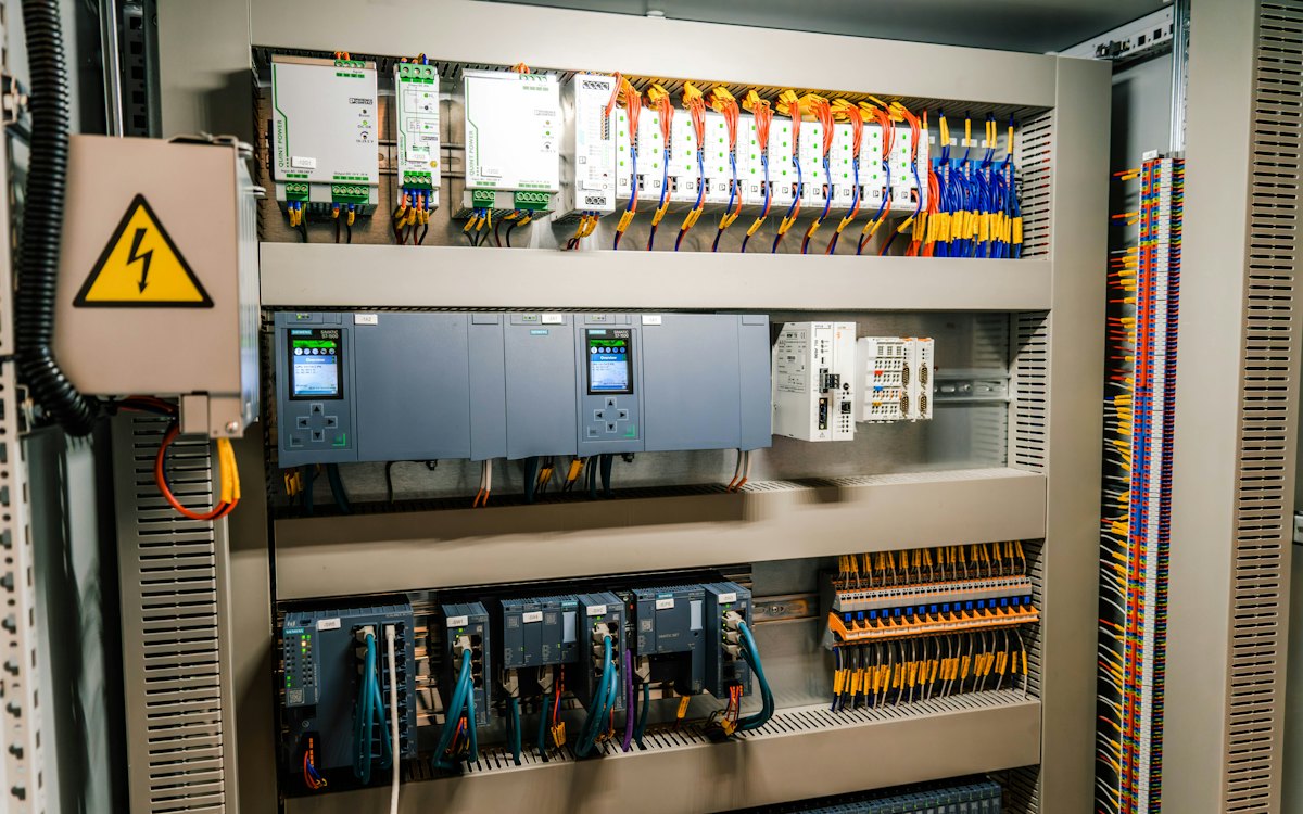 خزانة تحكم مفتوحة تضم وحدات PLC وأسلاكًا